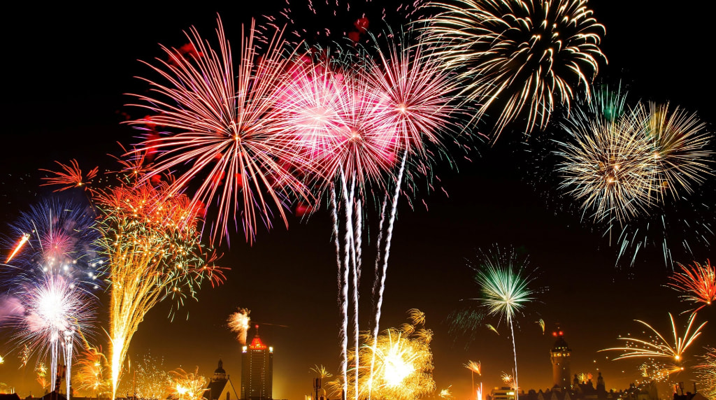 Fuochi d’artificio illuminano il cielo notturno sopra la città.