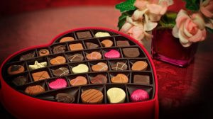 Scatola a cuore con cioccolatini assortiti e fiori