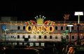 Insegna luminosa casinò notturno con parcheggio urbano illuminato
