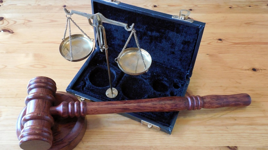Bilancia e martelletto giudiziario su tavolo in legno