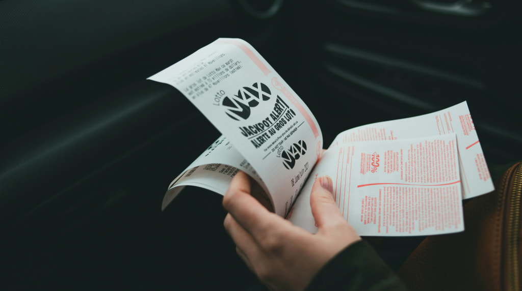 Iemand die in een auto meerdere jackpot-lotjes vasthoudt