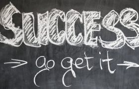 Witte krijtletters op een krijtbord, met de boodschap “succes, go get it”