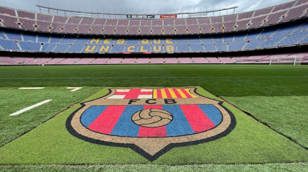 Leeg voetbalstadion met in het gras het logo van FC Barcelona