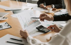 Zakenmensen aan vergadertafel die statistieken bekijken