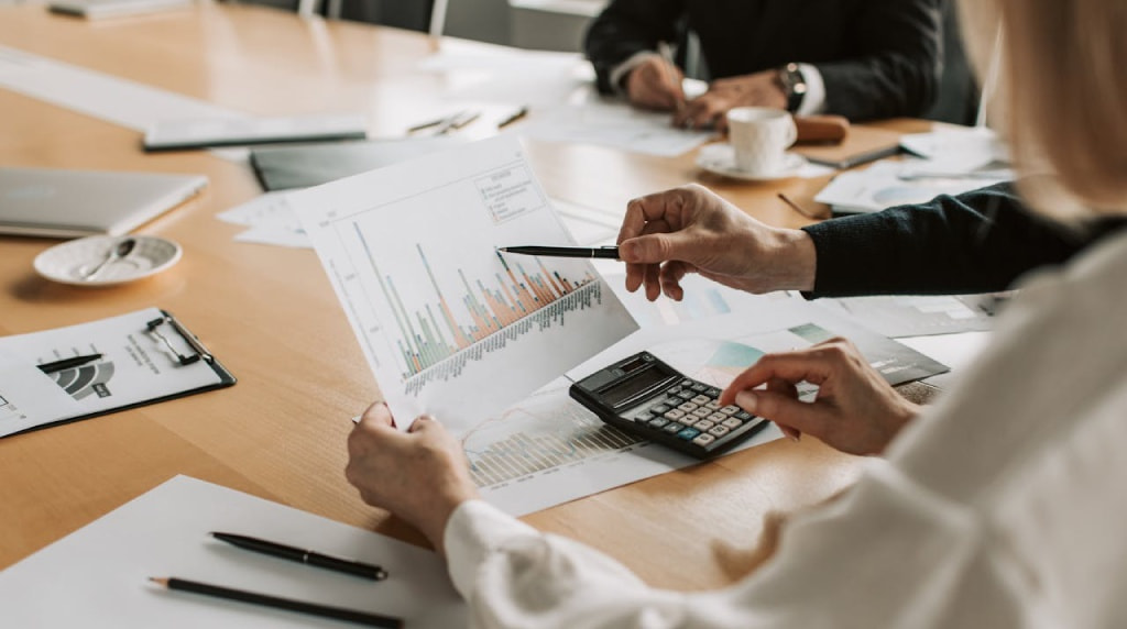 Zakenmensen aan vergadertafel die statistieken bekijken
