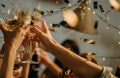 Handen die toosten op het nieuwe jaar met champagne en gouden glitters