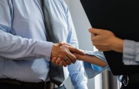 Twee zakenmensen die elkaar de hand schudden