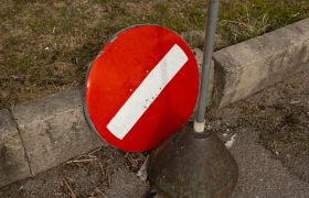Verkeersbord verboden, waarvan het bord zelf is afgebroken en op de weg ligt