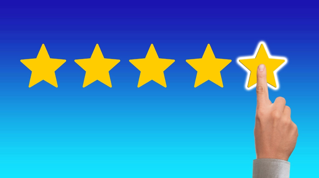 5 stele aurii pe fon albastru și un deget care arată evaluarea maximă.