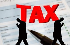 Grafică cu textul TAX în roșu și siluete de oameni