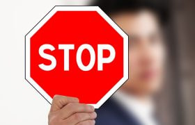 Semnul STOP ținut de o persoană