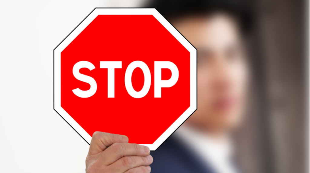 Persoană care ține semnul “STOP”