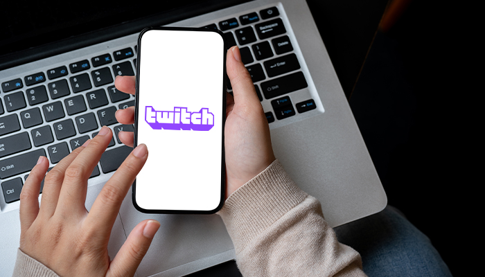 The twitch gambling app opened on a phone on top of a laptop