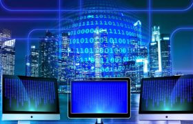 Computer monitors in front of city sape as information flows.